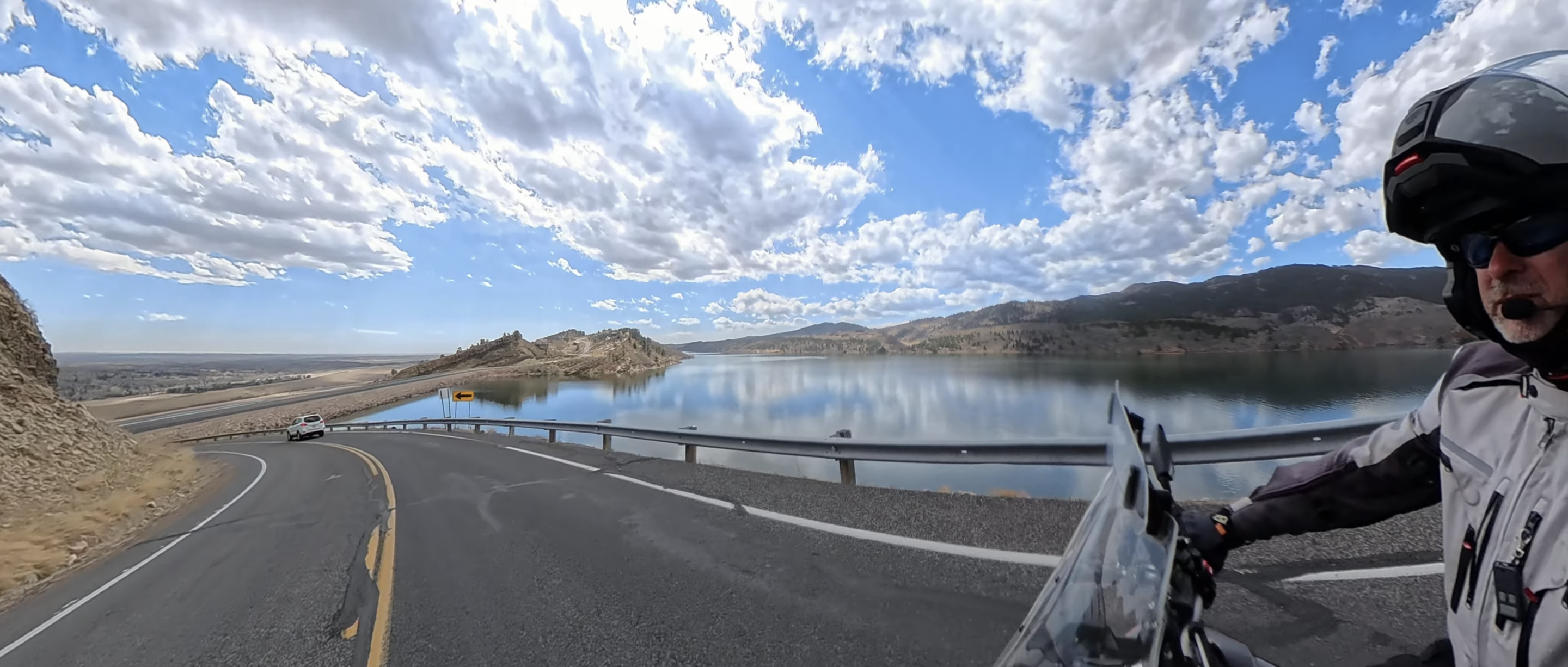 James Espy riding past a mountain reservoir